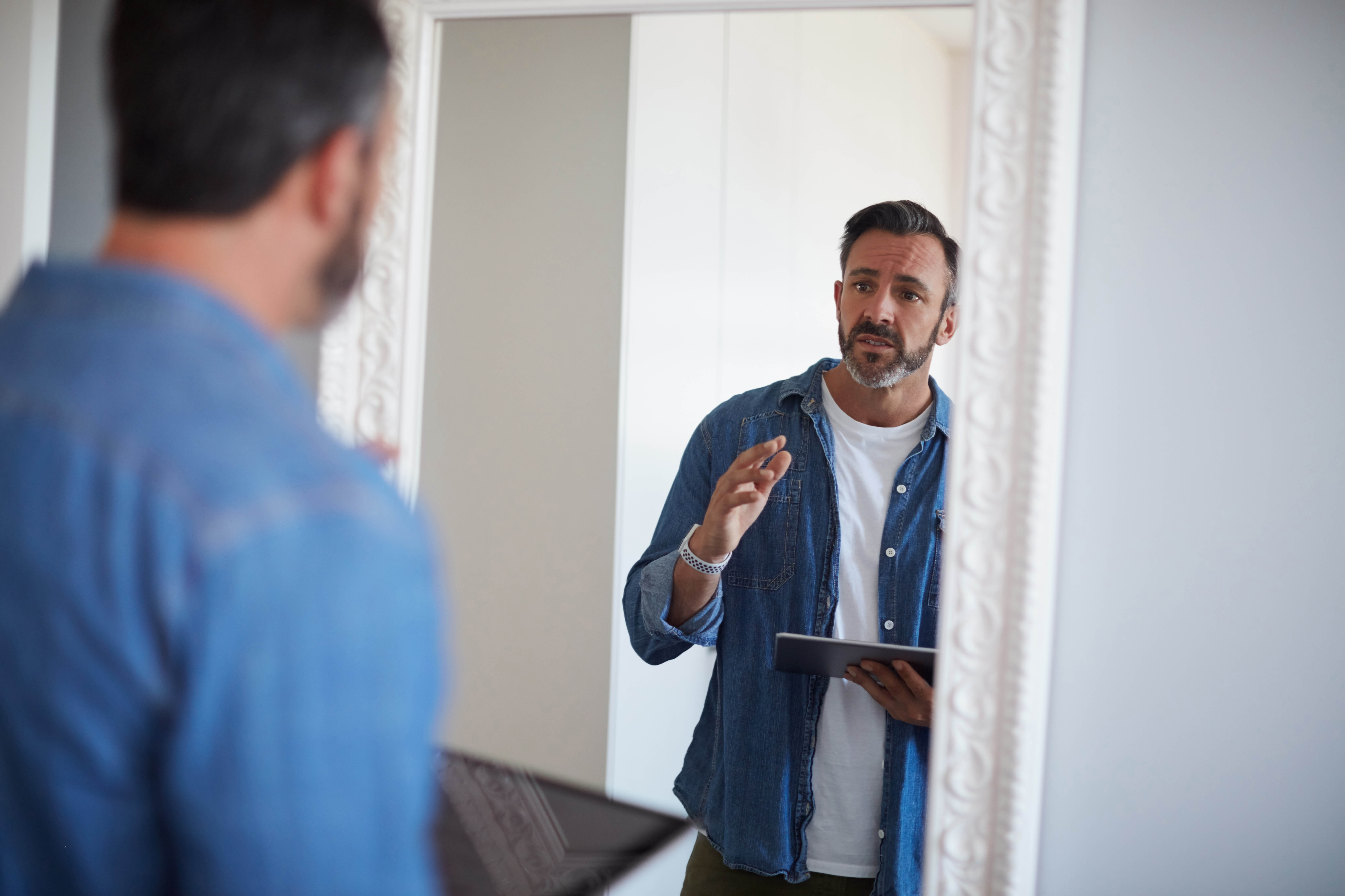 Man talking to himself and preparing a speech in the mirror Man talking to himself and preparing a speech in the mirror